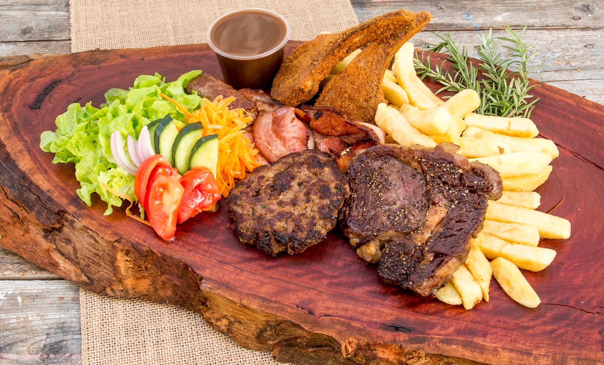 Mixed grill platter with steak, patty, bacon, lamb cutlets, salad and chips