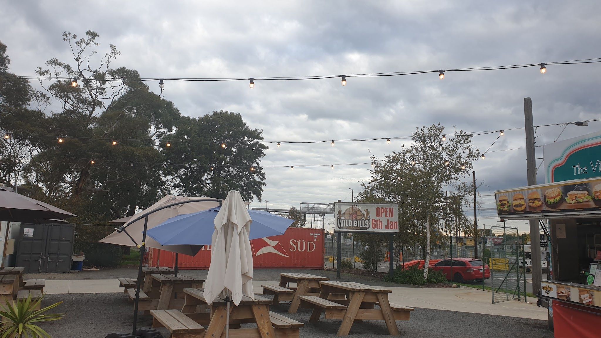 Outdoor picnic tables and string lights in the Chuck Wagon Food Village courtyard
