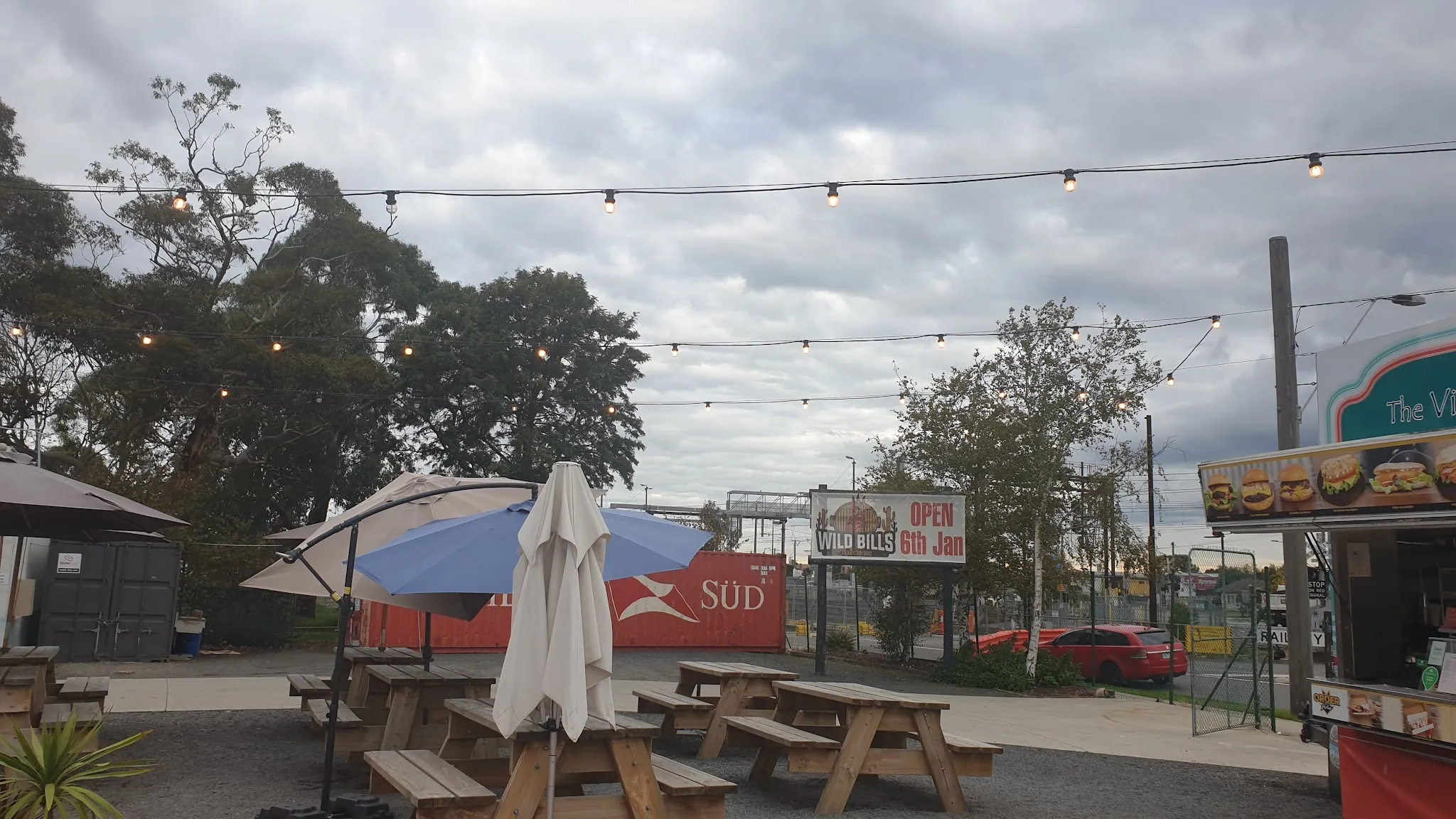 Outdoor picnic tables and string lights in the Chuck Wagon Food Village courtyard